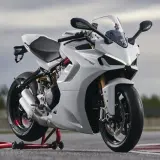 Eine weiße Ducati Supersport 950 steht auf einem roten Motorradständer. Das Motorrad hat einen sportlichen Look mit scharfen Linien und einem aerodynamischen Design.