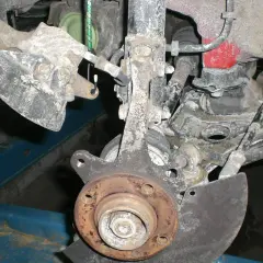 Vorderachse eines Golf 7, bereit für den Wechsel des Radlagers. Rostige Teile und Aufhängung sind sichtbar.