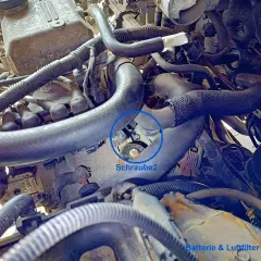 Motorraum eines Hyundai i30. Die Batterie und der Luftfilter sind entfernt. Eine Schraube am Anlasser ist markiert.