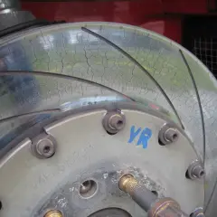Nahaufnahme einer Bremsscheibe mit feinen Rissen auf der Oberfläche.