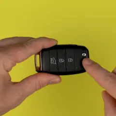 Hände halten Autoschlüssel für Kia Sportage, um die Batterie zu wechseln.