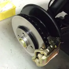 Frisch lackierte Bremsscheiben und ein goldener Bremssattel, bereit für den Einbau.