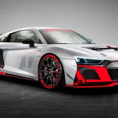 Silberner Audi R8 GT4 mit roten Akzenten, bereit für die Rennstrecke.