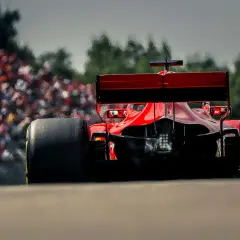Ein roter Formel 1 Bolide rast auf die Tribüne zu. Man fragt sich, wie viel PS ein Formel 1 Auto hat, wenn es so schnell ist.