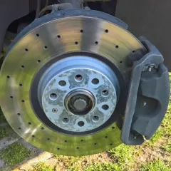 Ein gelochter Bremsscheiben-Power-Disc mit Bremssattel, bereit für die nächste Fahrt.