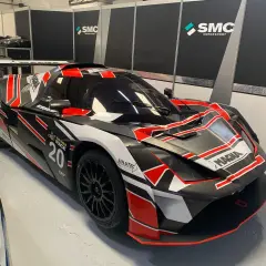 Ein rennfertiger KTM X-Bow GT4 in Schwarz mit roten und weißen Akzenten, bereit für die Jarama Race 20.
