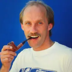 Ein Mann mit Schnurrbart, Reinhold Roth, hält eine Pfeife im Mund.