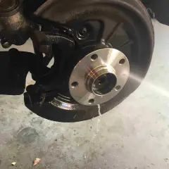 Radnabe eines Golf 5, bereit für den Wechsel des vorderen Radlagers. Flüssigkeit tropft auf den Boden.