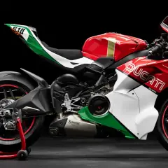 Rote Ducati Superleggera V4 mit italienischer Flaggenlackierung auf schwarzem Hintergrund.