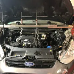 Motorraum eines Ford p0766, Motor wird mit Ketten und Stützen gehalten.
