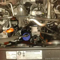 Anleitung zum Wechseln des Thermostats beim Golf 6 1.6 TDI. Motorraum mit sichtbarem Ölfilter und Kühlmittelbehälter.