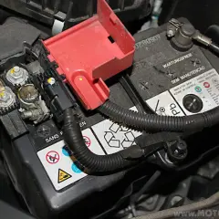 Batteriepole eines Honda Jazz, bereit für den Wechsel. Die roten Abdeckungen sind abgenommen, die Kabelanschlüsse sichtbar.