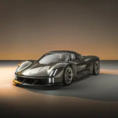 Grauer Supersportwagen mit futuristischem Design, beleuchtet von warmem Licht.