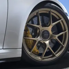 Porsche GT3 mit goldenen Felgen und gelben Bremssätteln. Die Keramik Bremsen Kosten sind hoch, aber die Leistung ist unschlagbar.