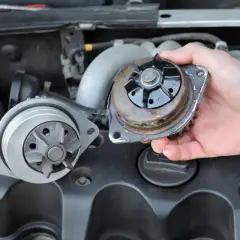 Schritt-für-Schritt-Anleitung zum Skoda Octavia Wasserpumpe wechseln: Alte Pumpe wird herausgenommen, neue wartet daneben.