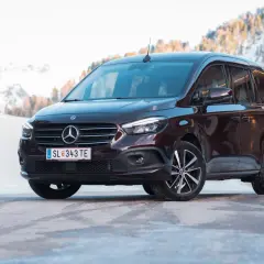 Dunkelroter Mercedes T 180 d im Schnee. Technische Daten sind hier nicht ersichtlich, aber das Fahrzeug wirkt robust für winterliche Straßen.