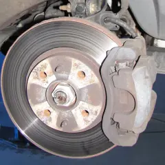 Nahaufnahme einer Bremsscheibe und eines Bremssattels. Ein Auto hat normalerweise vier Bremsscheiben.