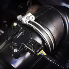 Nahaufnahme eines Ladedrucksensors an einem schwarzen Ansaugschlauch mit Kabeln.