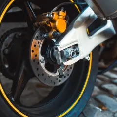Motorradbremse mit gelbem Bremssattel. Zeit für einen neuen Bremsbelag wechseln, um sicher unterwegs zu sein.