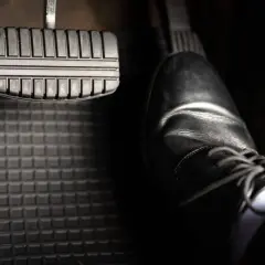 Ein Schuh steht bereit, um das Bremspedal zu betätigen. So weißt du, wo ist die bremse beim auto.