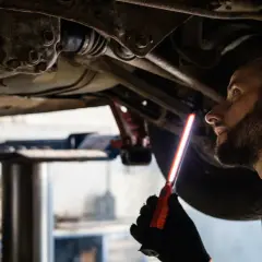 Mechaniker prüft das Fahrwerk eines Autos, um sicherzustellen, dass das audi s tronic Getriebe einwandfrei funktioniert.