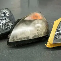 Scheinwerfer blind? Was tun? Drei Autoscheinwerfer nebeneinander: einer klar, einer trüb und einer abgeklebt.