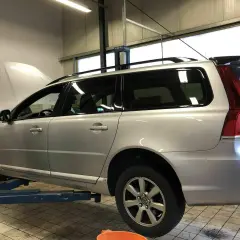 Silberner Volvo Kombi auf Hebebühne, Motorhaube offen. Gute Volvo Geartronic Erfahrungen sind wichtig für die Wartung.