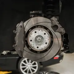 Nahaufnahme einer Bremsscheibe und eines Bremssattels. Die Bremsen quietschen ohne zu bremsen, was auf ein Problem hindeutet.