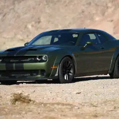 Grüner SRT Demon mit schwarzen Streifen parkt in der Wüste.