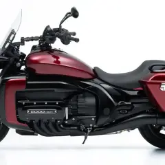 Rotes Motorrad mit großem Vierzylinder-Motor und Gepäcktaschen.