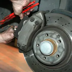 Mechaniker arbeitet an gelochter Bremsscheibe. Gute Quaro Bremsen Erfahrungen sind wichtig für die Sicherheit.
