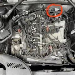 Motorraum eines Mercedes mit rotem Kreis um einen Sensor.