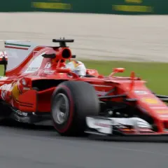 Ein roter Ferrari-Rennwagen rast über die Strecke, ein Meisterwerk der Formel 1 Technik, mit dem Fahrer im Cockpit.