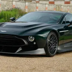 Der Aston Martin Victor, ein dunkelgrüner Supersportwagen, steht auf einem Kiesweg vor einer alten Mauer.