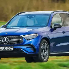 Blauer Mercedes-Benz GLC 300e PS fährt auf einer grünen Wiese.