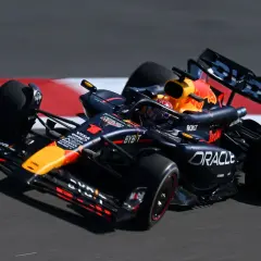 Formel 1 leistung: Ein schwarzer Red Bull Rennwagen rast über die Strecke, die Reifen drehen sich schnell.