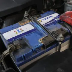 Eine defekte Autobatterie kann sich durch viele Symptome bemerkbar machen. Hier ist eine Varta-Autobatterie im Motorraum zu sehen.