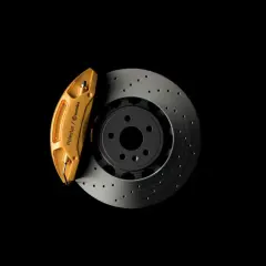 Goldener Bremssattel von Polestar/Brembo auf gelochter Bremsscheibe. So funktioniert eine Bremse: Reibung stoppt das Fahrzeug.