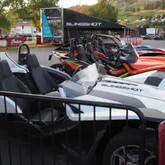Mehrere bunte Slingshot-Autos stehen nebeneinander, bereit für eine aufregende Fahrt.