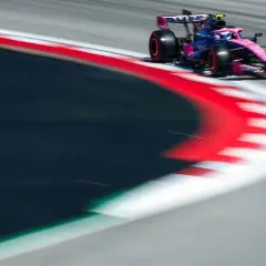 Ein Formel-1-Auto in Pink und Blau rast über die Rennstrecke. Dieses Bild fängt die Dynamik des Motorsports im TV perfekt ein.