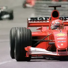 Ein roter Ferrari-Rennwagen rast auf der Strecke. Man fragt sich, was kostet ein Formel 1 Auto, wenn es so schnell ist?