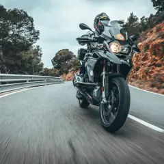 Fahrer auf einer BMW 1200 GS fährt auf einer kurvigen Bergstraße.