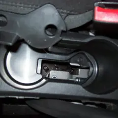 Detailaufnahme des Innenraums eines Opel Mokka, Fokus auf den Bereich um den Getränkehalter, wo das Handbremsseil gewechselt wird.