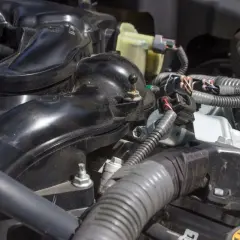 Detailaufnahme des Motors eines VW p0172. Schwarze Kunststoffteile und Kabelstränge sind sichtbar.