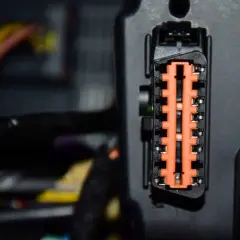 Nahaufnahme eines orangefarbenen Steckverbinders mit vielen Kontakten. Dies ist ein Teil der Elektronik, die für die Fahrdynamikregelung wichtig ist.