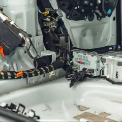 Innenraum eines Ford mit freiliegender Verkabelung und Sicherungskasten. Der p0700 Ford-Fehlercode deutet auf ein Problem mit dem Getriebesteuermodul hin.