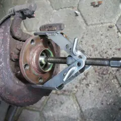Werkzeug zum Wechseln des Ankerblechs vorne an einem Golf 7. Rostiges Bauteil wird mit Spezialwerkzeug gelöst.