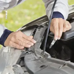 Person wechselt das Abblendlicht eines Skoda Fabia. Die neue Glühbirne wird vorsichtig in die Fassung eingeführt.