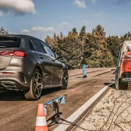 Testfahrt: Was bewirkt ein Antiblockiersystem (ABS)? Ein graues Auto bremst vor einem roten Auto, das mit einer Plane abgedeckt ist.