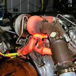 Glühender Turbolader eines p0234 vw Motors. Heiße Abgasanlage, Kabel und Metallteile.